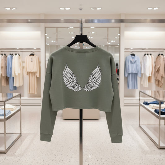 Green sweatshirt with wing design on a hanger in a store setting