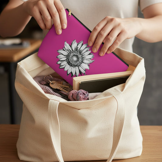 Person placing a pink case with a sunflower design into a beige tote bag.