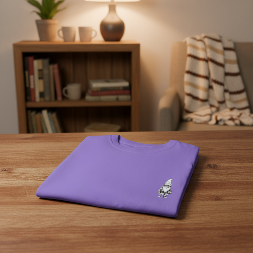 Folded purple t-shirt with a small embroidered design on a white background