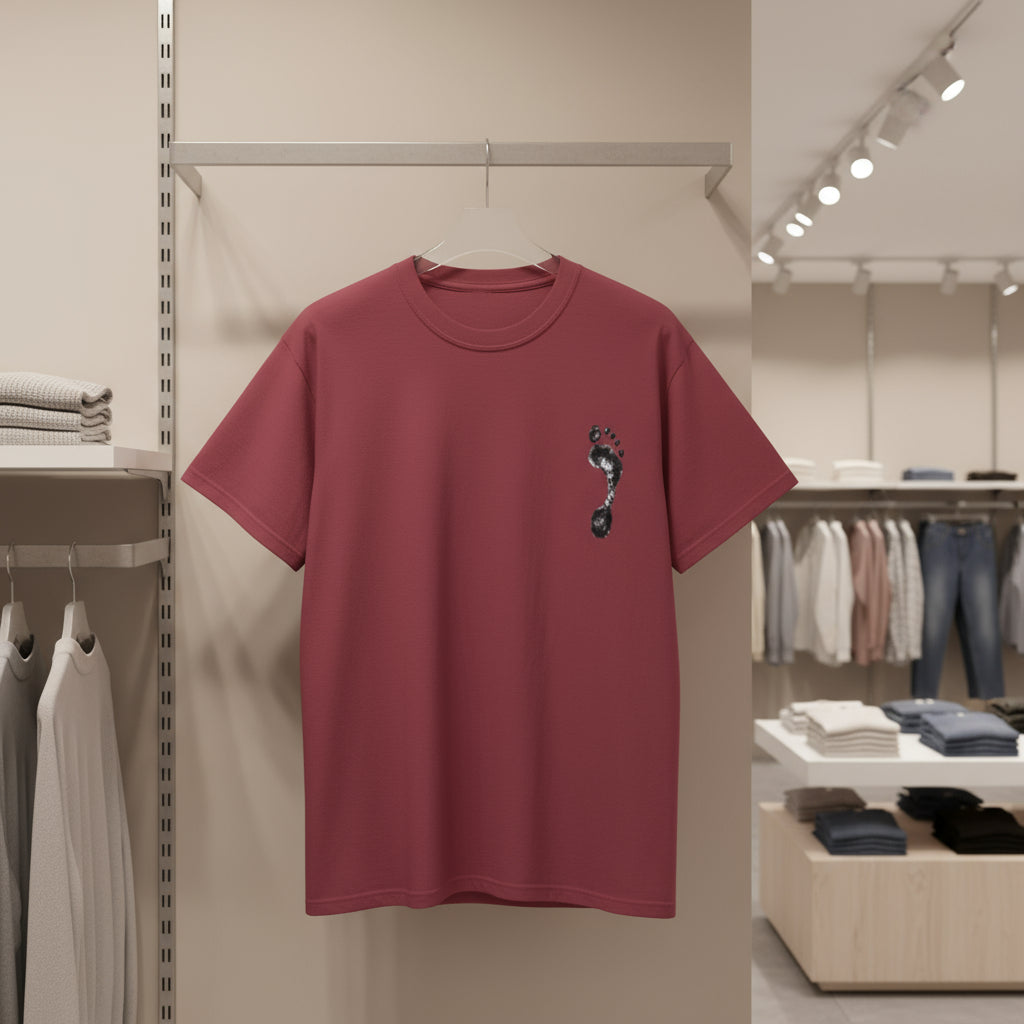 Maroon t-shirt with a small design on a hanger in a store setting