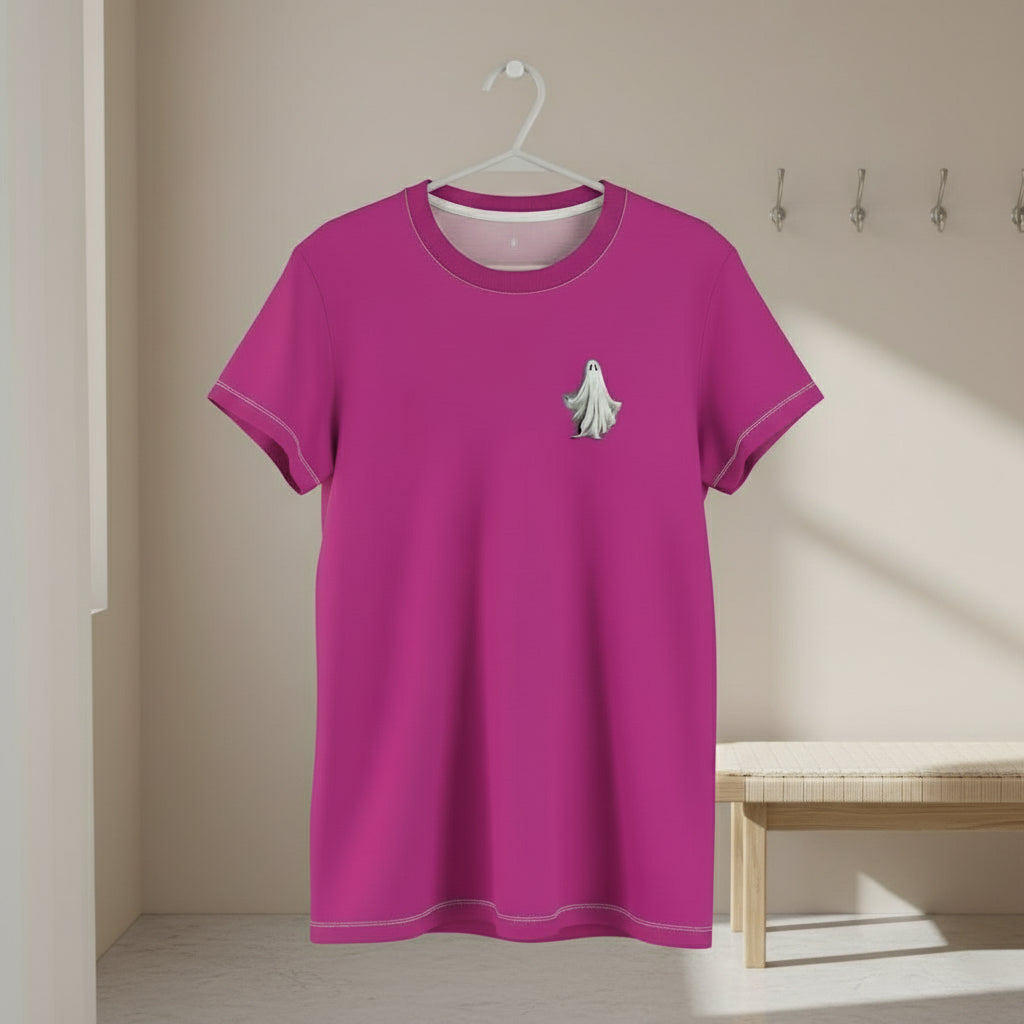 Pink t-shirt with a small design on a hanger against a beige wall.