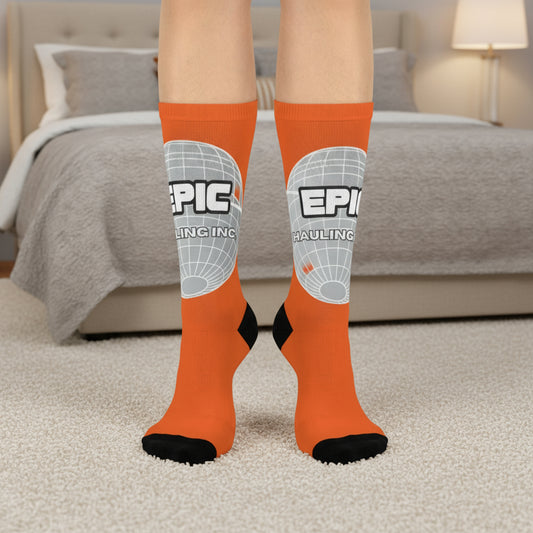 Orange socks with 'EPIC' branding worn indoors on a carpeted floor.