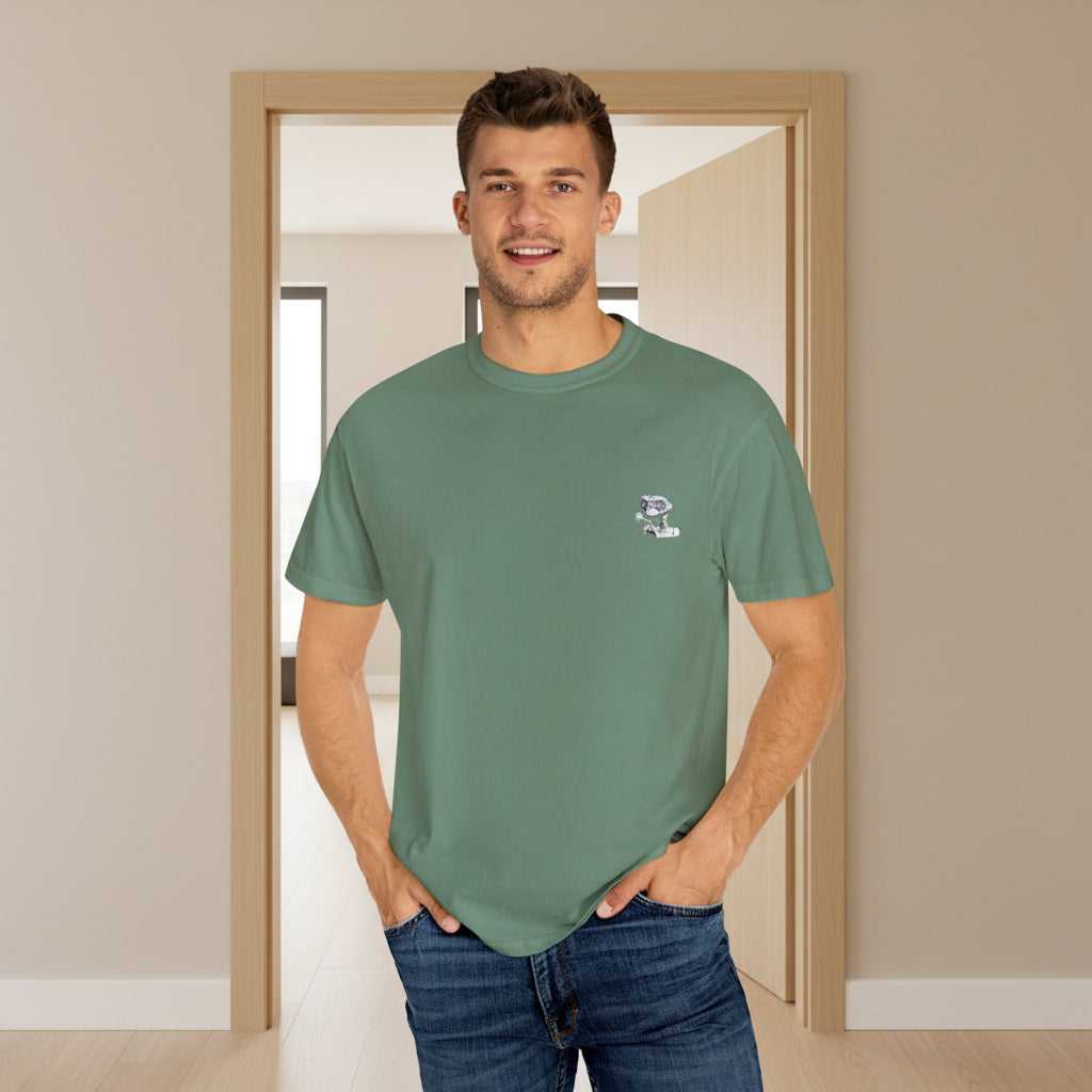 Man wearing a green t-shirt with a logo standing in a room with a door.