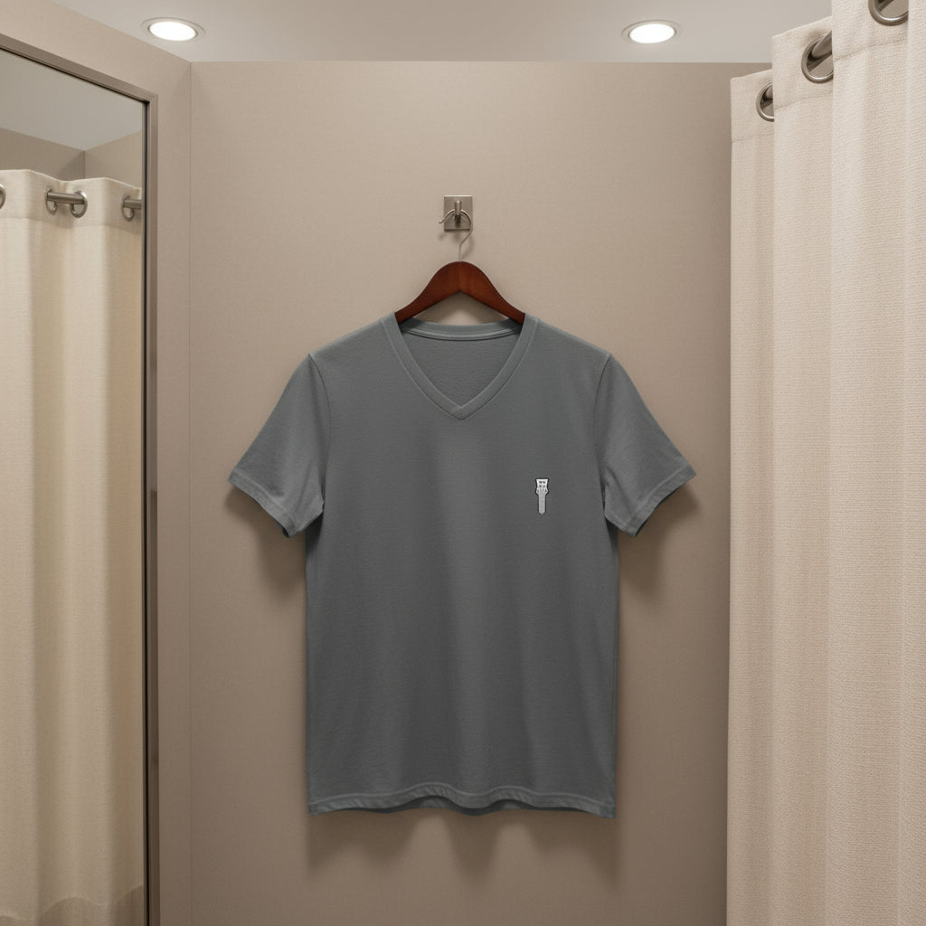 Gray t-shirt on a hanger against a beige wall.
