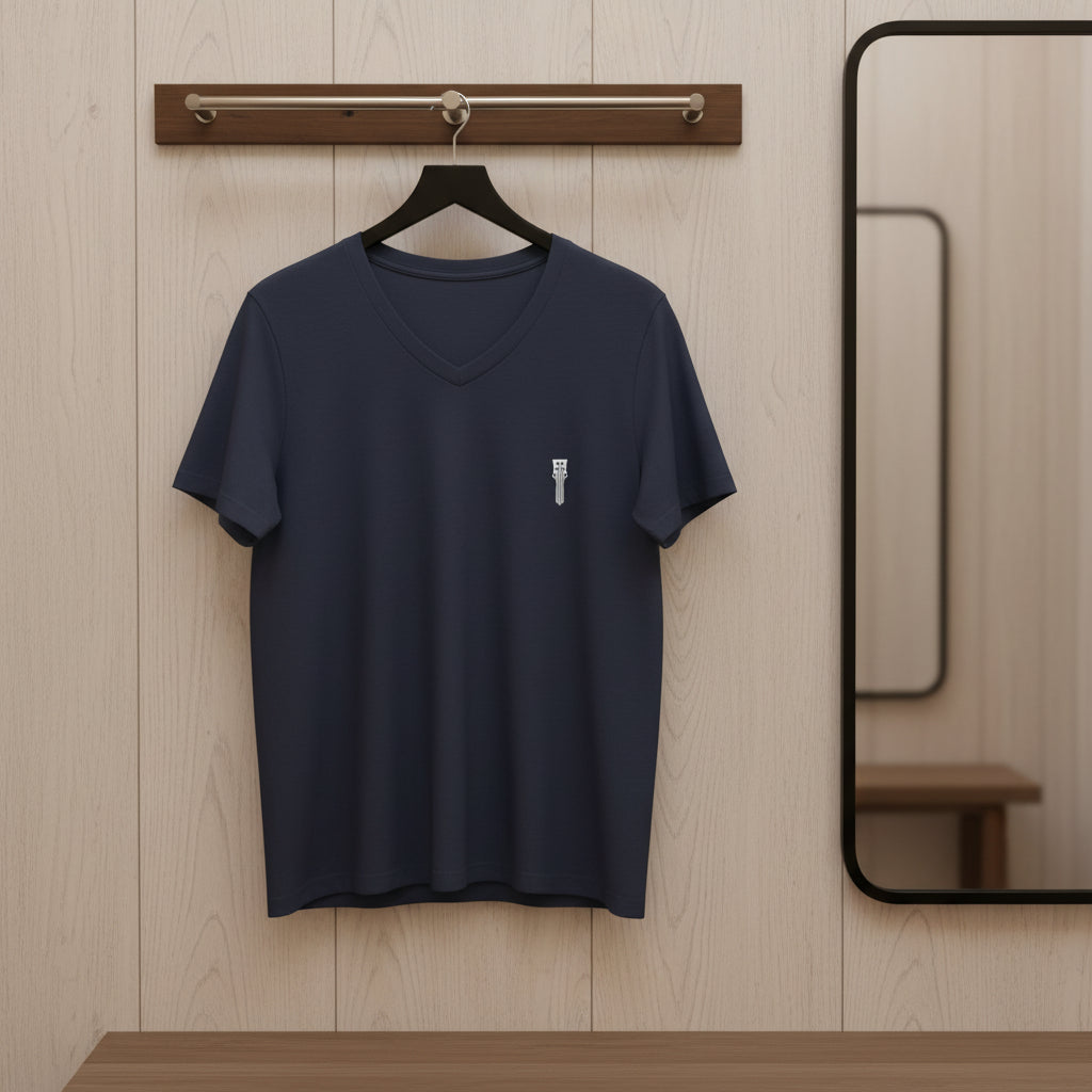 Navy blue t-shirt on a hanger against a wooden wall with a mirror.