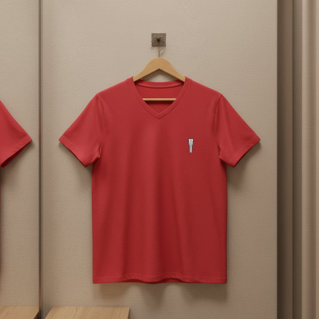 Red V-neck t-shirt on a wooden hanger against a beige wall.