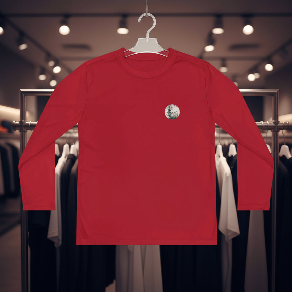 Red long-sleeve shirt with a small graphic on a hanger in a clothing store.
