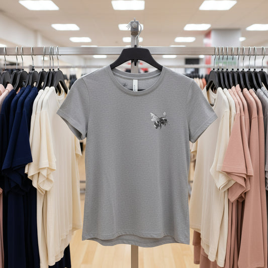 Gray t-shirt with a small design on a hanger in a clothing store.