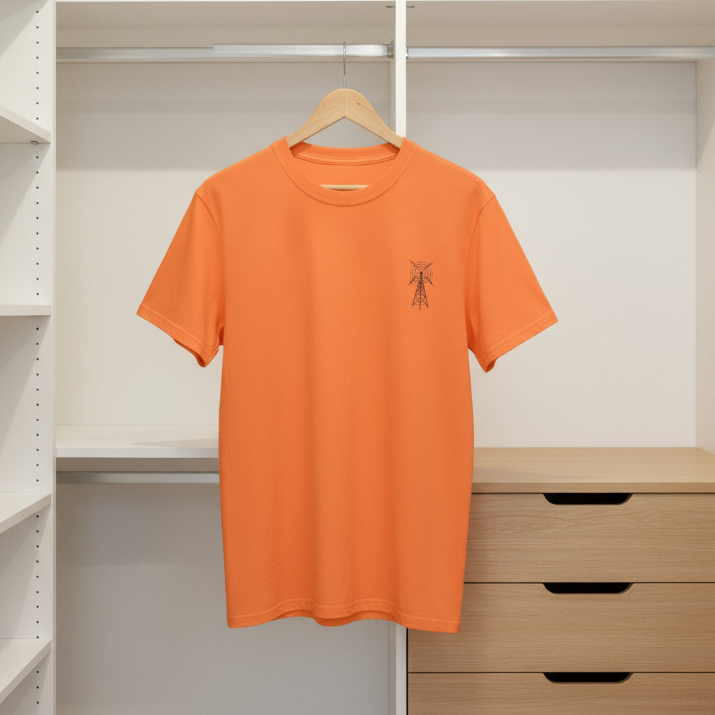 Orange t-shirt with a small logo on a hanger against a neutral background