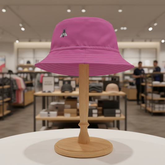 Pink bucket hat with a bee emblem on a white background